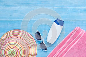 Flat lay of summer beach accessories on light blue wood plank fl