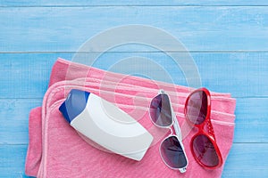 Flat lay of summer beach accessories on light blue wood plank fl