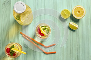 Flat lay of summer soda with lemon on green wood