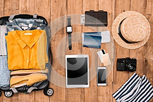 Flat lay of summer vacation things neatly organized on wooden background