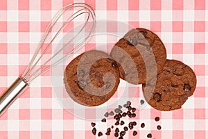 Flat lay of sweets, Chocolate brownie cookie and chocolate chip pieces on red gingham cloth
