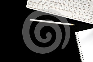 flat lay table with white keyboard, notepad and pencil