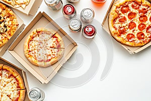 A flat lay of takeaway pizza boxes and soda cans arranged on a clean