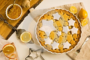 Flat lay tart with lemon, orange and ginger jam decorated with star-shaped cookies