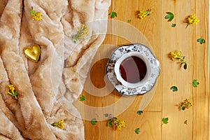 Flat lay of tea cup and yellow barberry flowers