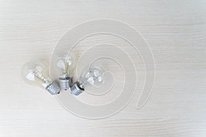 Flat lay of three light bulb on wooden table
