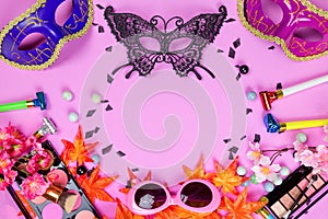 Flat lay top veiw of mask party preparation accessories. cosmetics and brushes on pink background