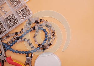 Beading tools flat lay on orange background