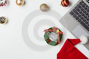 Flat lay top view Christmas office table desk party concept, Christmas workspace with laptop, Santa Claus hat and Christmas