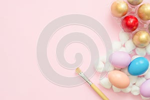 Flat lay top view colorful easter egg painted in pastel colors composition with paint brush on pink pastel color background.