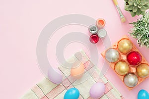 Flat lay top view colorful easter egg painted in pastel colors composition with paint brush on pink pastel color background.