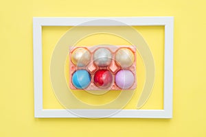 Flat lay top view colorful easter egg painted in pastel colors composition on yellow pastel color background.