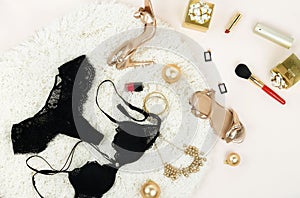 Flat lay, top view female black lingerie, high heels shoes sandals golden color, accessories , makeup, gifts