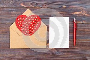 Flat lay. Top view. love letter on Saint Valentines Day. Handmade postcard with red heart shaped figure. Valentine day concept wit