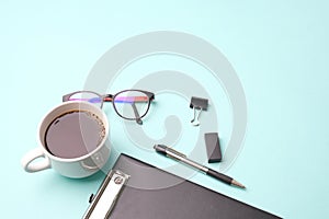 Flat lay top view modern office desk Workspace with blank clip board, eye glasses, office supplies, pen,and coffee cup on light