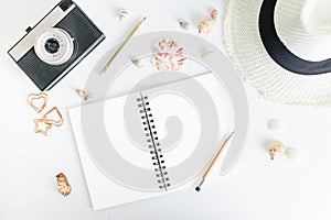 Flat lay top view notepad mockup: pencils, black beads, straw hat, seashells on white background. Clean and bright. Travel concept