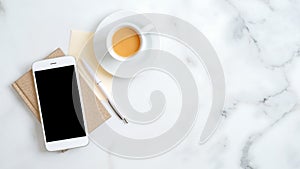 Flat lay, top view office table desk. Freelancer workplace with cup of coffee, paper notebook, office supplies and smartphone