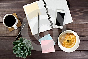 Flat lay, top view office table desk. Workspace with blank clip board, pencil, green leaf, and coffee cup on dark background.