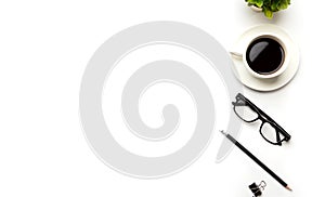 Flat lay, top view office table desk. Workspace with blank, office supplies, pencil, green leaf, and coffee cup on white