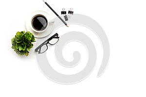 Flat lay, top view office table desk. Workspace with blank, office supplies, pencil, green leaf, and coffee cup on white