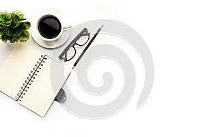 Flat lay, top view office table desk. Workspace with blank, office supplies, pencil, green leaf, and coffee cup on white