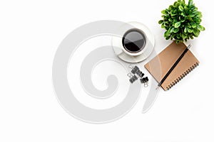 Flat lay, top view office table desk. Workspace with blank, office supplies, pencil, green leaf, and coffee cup on white