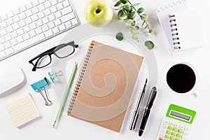 Flat lay, top view office table desk. Workspace with keyboard, office supplies, pencil, green leaf, and coffee cup with copy space