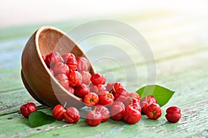 Flat lay top view Red Acerola Cherry in wooden bowl photo