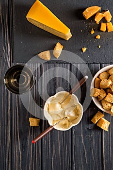 Flat lay. Traditional french cheese fondue. Crouton dipped into hot cheese fondue on a long-stemmed fork.