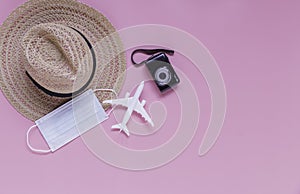 Flat lay travel accessories on a pink background and travelling during covid-19 epidemic concept