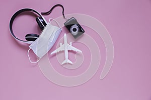 Flat lay travel accessories on a pink background and travelling during covid-19 epidemic concept