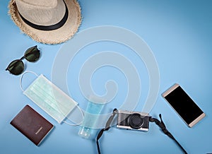 Flat lay of traveling accessories with hygienic mask and sanitizer gel  on blue  background with copy space ,protection from