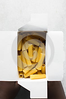 Flat lay of uncooked tortiglioni pasta shells in box