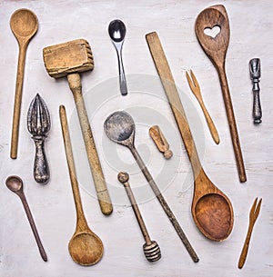Flat lay variety of wooden cutlery, spoons, forks, meat beater wooden rustic background top view close up
