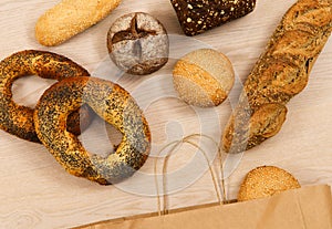 Flat lay. Various shapes of pastries spilled out of a paper shopping bag onto the table.