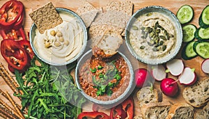 Flat-lay of Vegetarian dips hummus, babaganush, muhammara