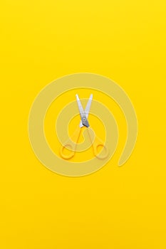 Flat lay vertical shot of opened yellow scissors with central composition