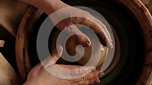 Flat lay view from above female hand taking clay to work on pottery wheel