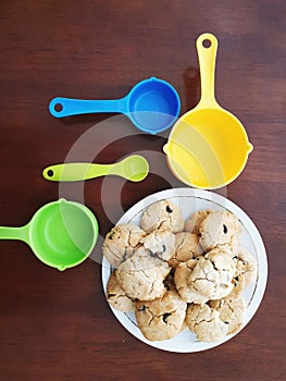 Flat lay view of chocolate chip cookie and measuring cups