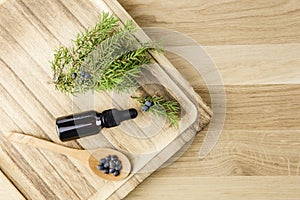 Flat lay view Juniper latin Juniperus communis berry essential oil in brown dropper bottle.