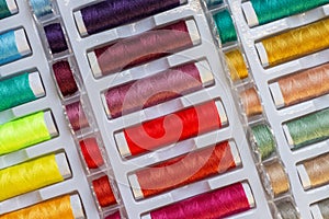 Flat lay view of rainbow threads and plastic bobbins for sewing machines