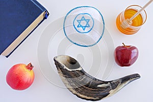 Flat lay view of Shofar, Torah book, Kippa, apple, honey and Pom