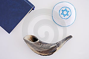 Flat lay view of Shofar, Torah book and Kippa background