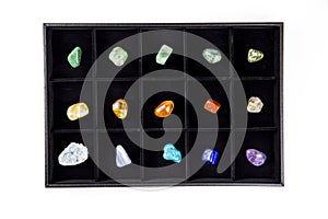 Flat lay view of variety of colorful semi precious stones crystals in organizer box.