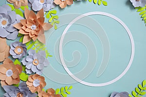 Flat lay of vintage round card frame, color paper flowers design on blue background. Top view, copy space, floral artFlat lay of v