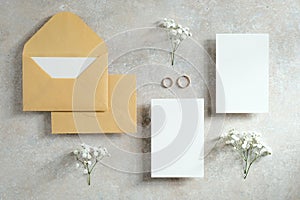 Flat lay wedding invitations cards mockups with flowers and rings. Love, romance concept