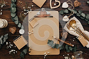 Flat lay Wedding planning. Craft clipboard with rustic decorations on wooden background