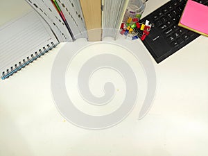 Flat lay, white desk in the office with layout space.with office equipment such as pencils, notebooks and keyboards at the top.