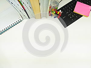 Flat lay, white desk in the office with layout space.with office equipment such as pencils, notebooks and keyboards at the top.