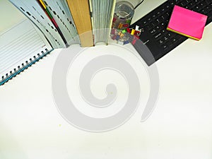 Flat lay, white desk in the office with layout space.with office equipment such as pencils, notebooks and keyboards at the top.